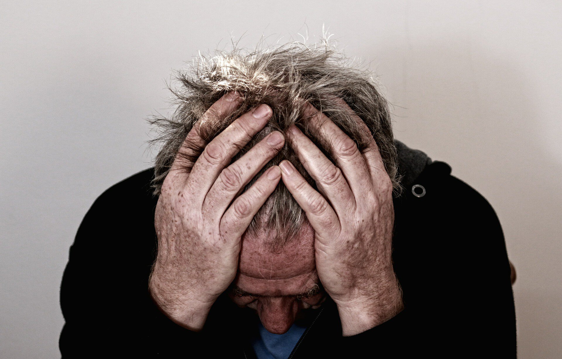 Migraine treatment patient model with his head in his hands