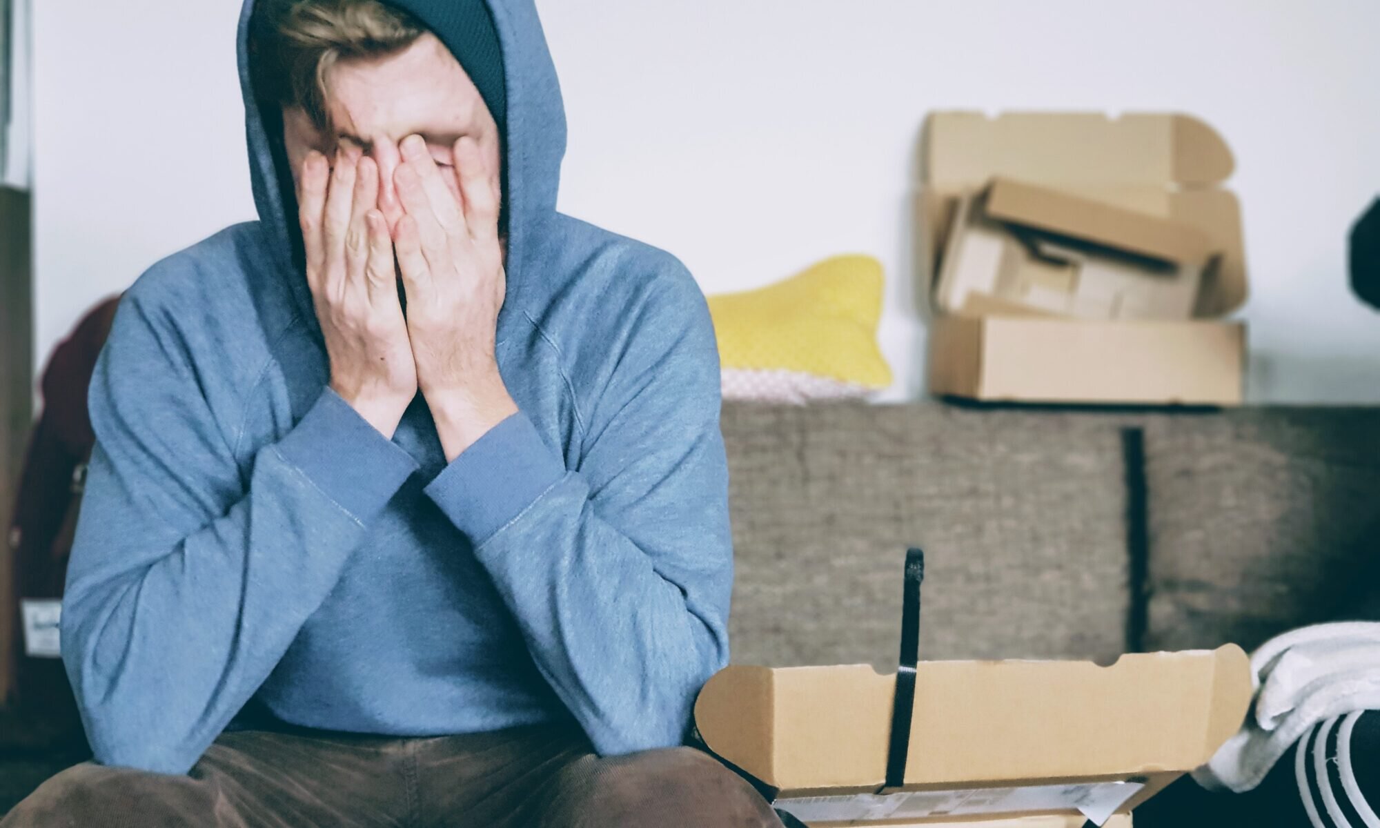 Sherman Oaks tinnitus treatment patient model wearing a hoodie with his face in his hands